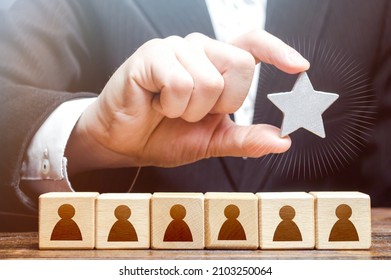 A businessman is holding a star over the team. Awarding. High appreciation and reward for work. Optimal team size, efficiency and productivity. Recruiting the best job applicants. - Powered by Shutterstock