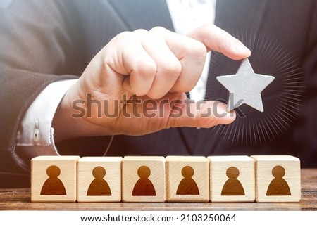 A businessman is holding a star over the team. Awarding. High appreciation and reward for work. Optimal team size, efficiency and productivity. Recruiting the best job applicants.