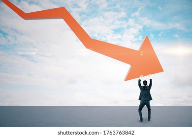 Businessman holding stock crash red arrow on cloud background. Business and financial crisis concept.