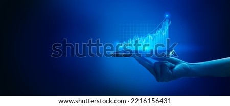 Businessman holding stock mobile phone and market economy graph statistic showing growth of profit analyzing financial exchange on blue background.Concept of growth planning and business strategy.