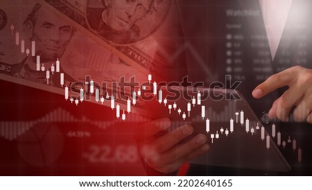 Businessman holding tablet analyzing downtrend crisis of stock market exchange with double exposure us dollar background and candle graph charts. Financial concept. Recession in America economy.