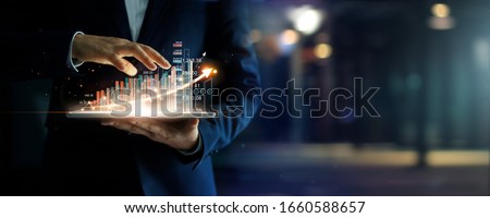 Businessman holding tablet analyzing sales data and economic growth graph chart, Business strategy and planning, Digital marketing and stock market. 