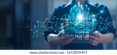 Businessman holding tablet and checking analyzing sales data growth graph chart and stock market on global networking. Business strategy, planning and digital marketing on blue background.