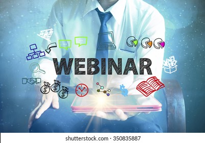 Businessman Holding A Tablet Computer With WEBINAR Text ,business Concept