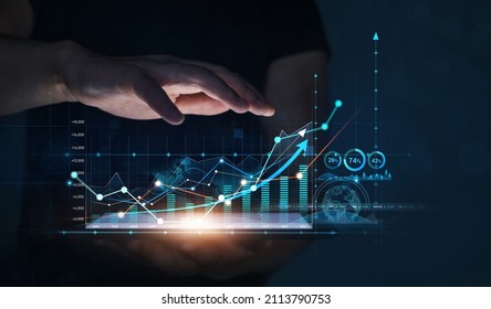 Businessman holding tablet with growing virtual hologram of statistics. Business planning and strategy. Digital marketing and growth graph chart. - Shutterstock ID 2113790753