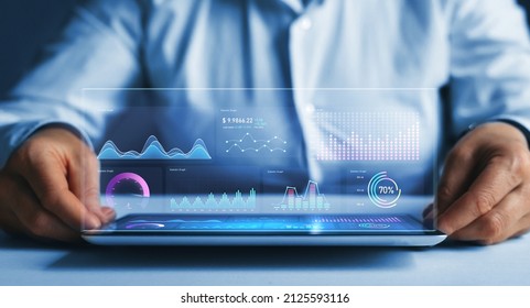 Businessman holding tablet with growing virtual hologram of statistics, graph and chart.Chart graph elements for data analytics and statistics. Stock market investment. - Powered by Shutterstock