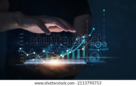 Businessman holding tablet with growing virtual hologram of statistics. Business planning and strategy. Digital marketing and growth graph chart.