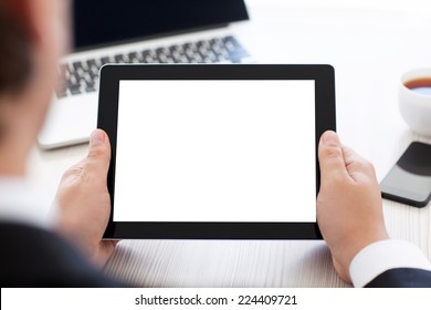 businessman holding a tablet with isolated screen over a table in the office