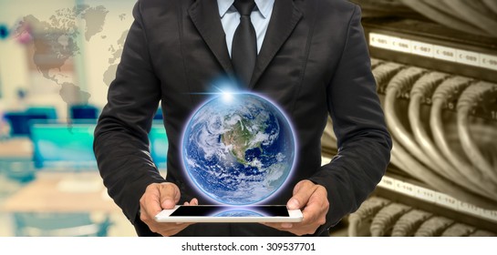 Businessman Holding The Tablet On Abstract Blurred Photo Of Empty Computer Room With Earth And World Map,Elements Of This Image Furnished By NASA