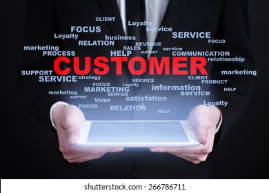 Businessman holding a tablet pc with customer text on virtual screen. Internet concept. Business concept.