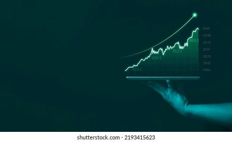 Businessman holding tablet showing stock market graph chart gain profit , Business investment planing growth and economic increasing strategy concept.  - Shutterstock ID 2193415623