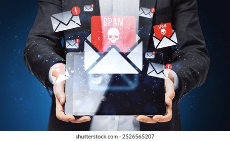 Businessman holding a tablet with spam email icons floating around. Holographic style with a dark blue background. Concept of digital spam and cybersecurity threats