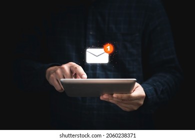 Businessman holding tablet and touching with virtual white newsletter for electronic mail or E-mail with notification alert concept. - Shutterstock ID 2060238371