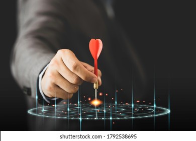 Businessman holding and throwing red arrow dart to virtual target dart board. Setup objectives and target for business investment concept. - Shutterstock ID 1792538695