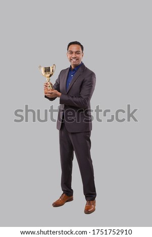 Businessman Holding Trophy. Indian Businessman Standing Full Length with Trophy in Hands