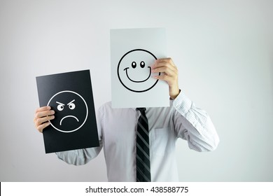 Businessman Holding Two Papers With Happy And Angry Face Each On Them