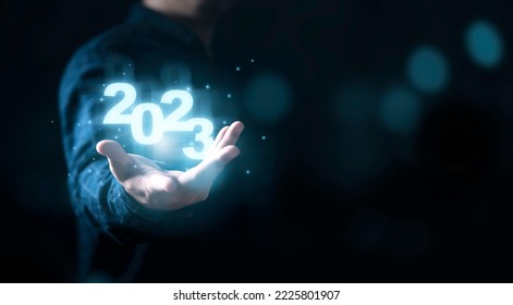 Businessman holding virtual 2022 number with blue bokeh background and copy space for merry Christmas and happy new year concept. - Shutterstock ID 2225801907