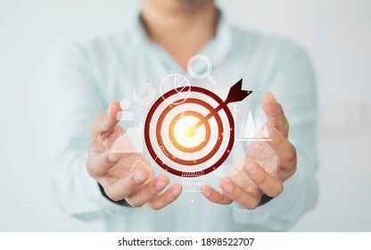 Businessman holding virtual dartboard with arrow ,Business Achievement objective target concept. - Shutterstock ID 1898522707