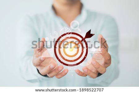 Businessman holding virtual dartboard with arrow ,Business Achievement objective target concept.
