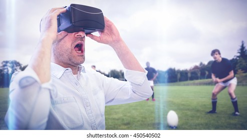 Businessman Holding Virtual Glasses Against Rugby Players Training On Pitch