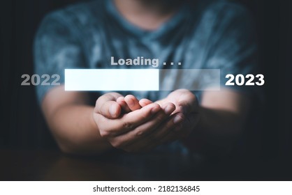Businessman holding virtual loading bar for count down from 2022 to 2023 year of preparation merry Christmas and happy new year concept. - Shutterstock ID 2182136845
