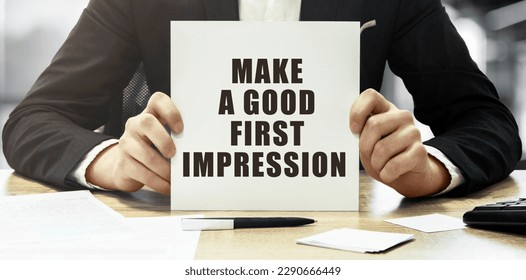 Businessman holding a white card with text Make a good first impression on office background