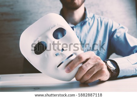 Businessman holding white mask in his hand