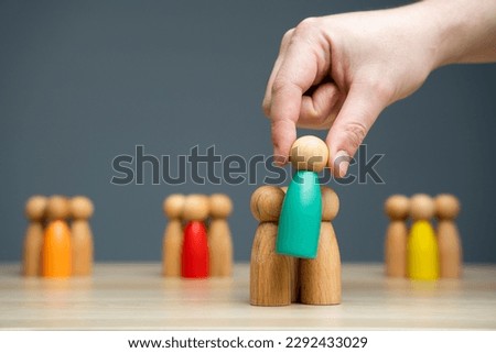 Businessman holding a wooden man in his hand. The concept of market segmentation. Target audience, customer care. Market group of buyers. Customer relationship management. Selective focus
