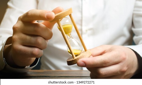 Businessman holds clock in hands. Concept of saving time and money. Time management. Planning work. Reduced cost and bureaucratic burden. Saving productivity. Extension of life. Debt / tax holidays