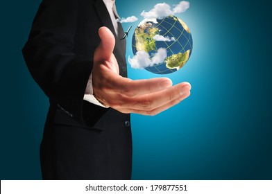 Businessman holds Earth in a hand with airplane and cloud.  Elements of this image furnished by NASA  