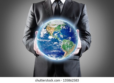 Businessman holds earth in a hands.Elements of this image furnished by NASA