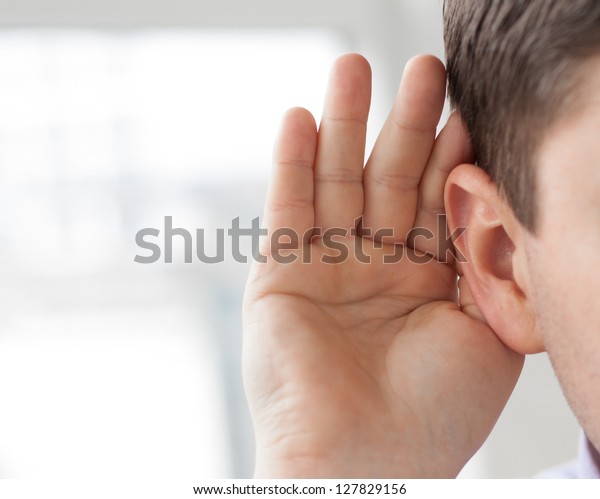 Businessman holds his hand near his ear and
listening something