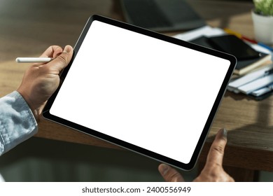 A businessman holds a mockup. iPad digital tablet with blank screen Mockup replaces your design mockup in the office.