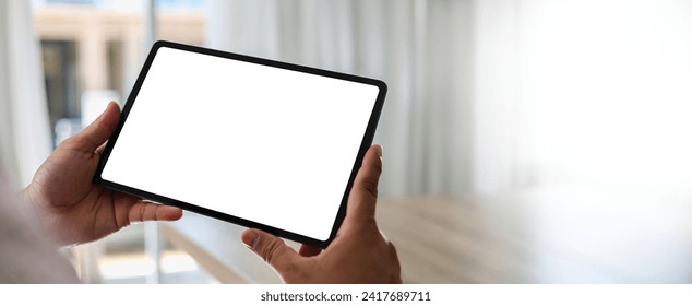 A businessman holds a mockup. iPad digital tablet with blank screen Mockup replaces your design mockup in the office. - Powered by Shutterstock