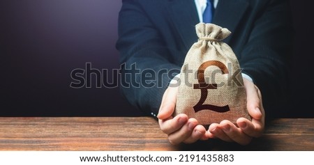 Businessman holds out british pound sterling money bag. Getting a grant. Mortgage, loan approval. Salary, benefits, profit. Attracting investments. Deposit savings. Banking and crediting. Easy Money.