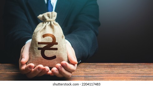 Businessman Holds Out Ukrainian Hryvnia Money Bag. Financial Support For Ukraine. Getting A Grant. Mortgage, Loan Approval. Attracting Investments. Deposit Savings. Cashback. Banking And Crediting.