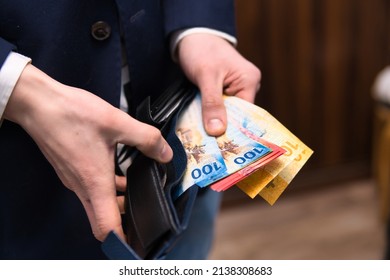 businessman holds Swiss francs in various denominations. Placing your savings in Swiss francs as a safe and stable currency - Shutterstock ID 2138308683
