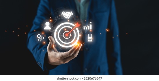 Un hombre de negocios sostiene iconos virtuales que representan objetivos de negocio, estrategia, análisis, trabajo en equipo y éxito.