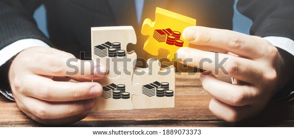 Businessman holds the wooden puzzle with a\
picture of money. The concept of financial management and\
distribution of funds. Saving and investing. Property division.\
Divorce and legal\
services