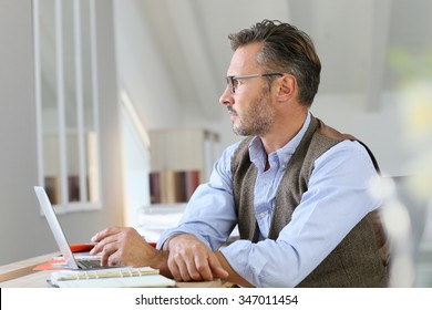 Businessman at home looking away through window - Powered by Shutterstock