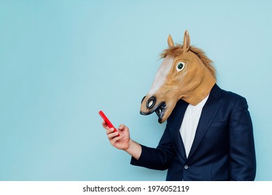 Businessman with horse mask using smartphone - Powered by Shutterstock