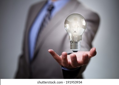Businessman with illuminated light bulb concept for idea, innovation and inspiration