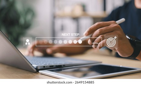 Businessman interacting with digital progress bar and “Next Step” interface on laptop and tablet. Concept of business development, decision making, and digital process.