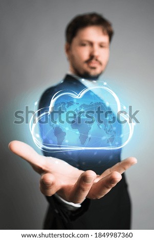 businessman interacting with a virtual cloud in front of grey background
