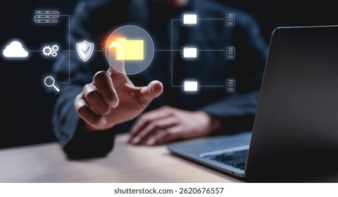 Businessman interacts with a virtual folder icon on a digital interface next to a laptop, symbolizing data management and technology. - Powered by Shutterstock - Get 15% off with code: PIKWIZARD15