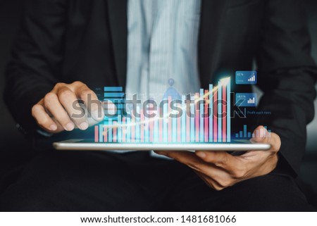 Businessman investor analyzing company financial statistic report working with digital augmented reality graphics technology. Concept for business, economy and marketing fund.