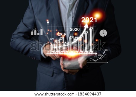 Businessman investor man hand holding trend chart growing up from 2020 to 2021, Business investment growth up concept.