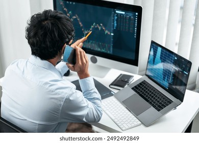 Businessman investor working with smartphone and computer analyzing graph stock market trading planning with chart data financial investment planning.