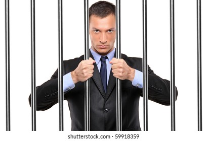 A Businessman In Jail Holding Bars Isolated On White