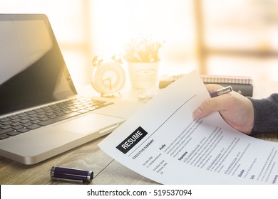 Businessman or job seeker review his resume on his desk before send to finding a new job with pen, necktie, glasses and digital tablet. - Shutterstock ID 519537094
